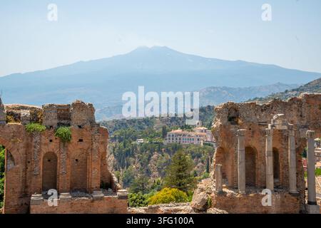 Aktiver Vulkan Etna, gesehen durch Steinpfeiler des antiken Teatro Antico, griechischen Amphitheaters von Taormina, Sizilien Stockfoto