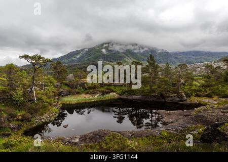 Bergsee-Reflektionen unter dramatischen Wolken in Vikedal, Rogaland, Norwegen Stockfoto