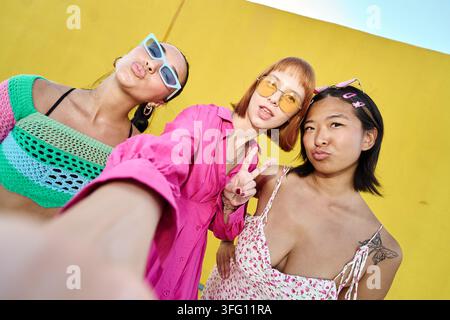 Junge vielfältige Freundinnen, die für ein Selfie posieren, lächeln und zusammen lustige Gesichter machen, zeigen Freundschaft und Jugend Stockfoto
