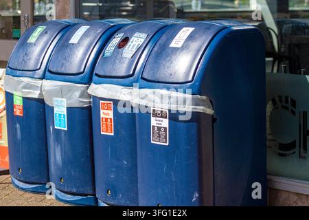 Eine Reihe farbcodierter Recycling- und Mülltonnen mit klaren Anweisungen für verschiedene Abfallarten. Southport, UK. Stockfoto