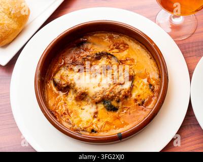 Appetitliches ägyptisches Moussaka aus Schichten gebratener Auberginen in Tomatensauce und würziger Hackfleisch, mit Käse bestreut und in einer Tontschüssel gebacken Stockfoto