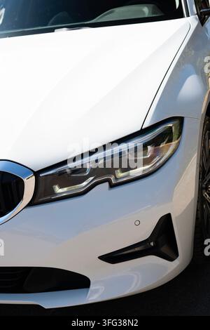 Weißes BMW 320i Limousine Scheinwerfer Nahaufnahme Detail Stockfoto