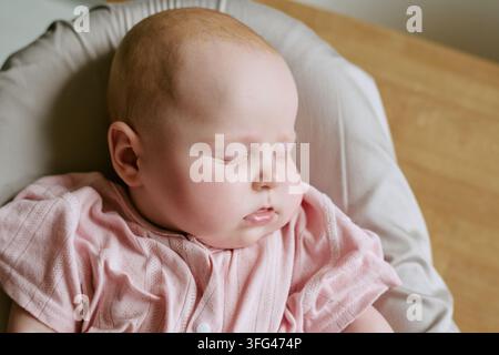 Süßes Baby-Mädchen schläft friedlich in der Schaukel zu Hause Stockfoto
