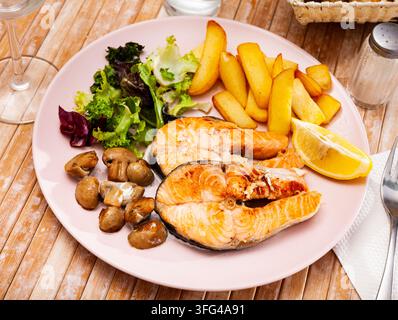 Lachs mit Kartoffeln und Pilzen ist ein leckeres Gericht in der Küche Stockfoto