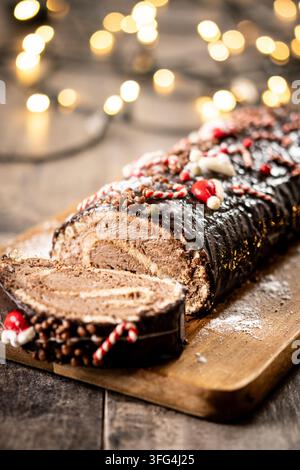 Weihnachts-Schokoladen-Rollkuchen auf Holztablett Stockfoto