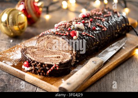 Weihnachts-Schokoladen-Rollkuchen auf Holztablett Stockfoto