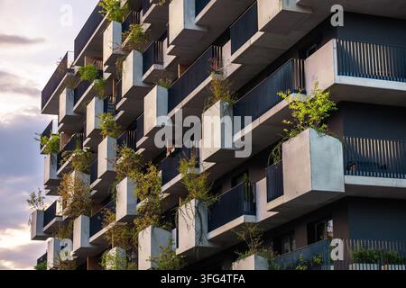 moderne Architektur umweltfreundliche Wohnhausfassade mit gestuften geometrischen Betonbalkonen grünen Pflanzen Grünflächen vertikaler Garten urbaner Raum Stockfoto