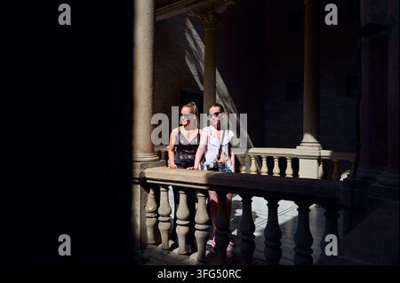 Zwei Frauen mit Sonnenbrillen genießen einen sonnigen Balkon Stockfoto