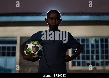 (260911) -- NAIROBI, 11. Sept. 2026 (Xinhua) -- Ein Junge spielt Fußball unter solarbetriebener Beleuchtung auf dem Spielplatz des Mukuru Skills Training Center in Nairobi, Kenia, am 10. Sept. 2026. Kürzlich installierte die kenianische Nichtregierungsorganisation Mukuru Slums Development Projects (MSDP) mehrere in China hergestellte Solarpaneele und Beleuchtungsanlagen im Mukuru Skills Training Center, wodurch straßenverbundenen Kindern, die dort Unterstützung erhalten, eine stabilere Lichtquelle zur Verfügung steht und es ihnen somit erleichtert wird, nachts auf dem Spielplatz zu spielen und zwischen Schlafsälen und Toiletten zu gehen. (Xinhua Stockfoto