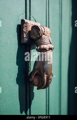 Ein antiker Türklopfer aus Gusseisen an einer alten, verwitterten Holztür, Montmartre, Paris, Île-de-France, Frankreich Stockfoto
