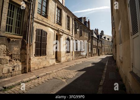 Kopfsteinpflasterstraße gesäumt von traditionellen historischen Steinbauten und Holzfensterläden im historischen Zentrum von Bourges, Cher, Frankreich. Stockfoto