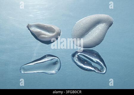 Hautpflege-Produkttexturen: Creme, Gel, Serum und Schaumtropfen auf blauem Hintergrund für Kosmetikvisuals Stockfoto