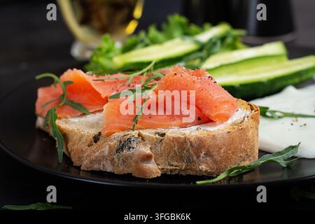 Geräuchertes-Lachs-Sandwich mit Frischkäse und frischem Rucola Stockfoto