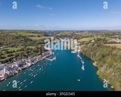 Eine Luftaufnahme, die landeinwärts entlang des Fowey-Flusses in Cornwall an einem sonnigen Tag zeigt. Die malerische Flussmündung ist mit zahlreichen festgemachten Segelbooten gefüllt und y Stockfoto