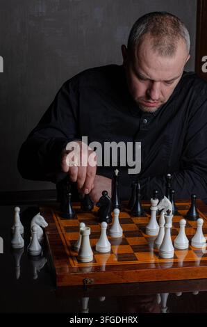 Mann spielt Schach an einem Schachbrett Stockfoto