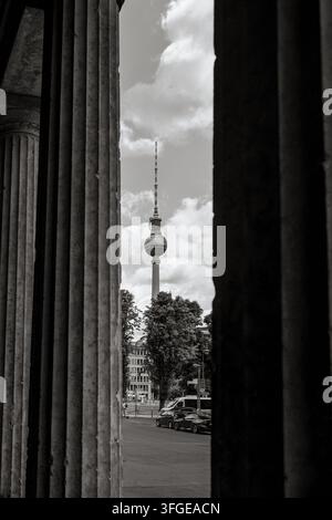 Schwarz-Weiß-Ansicht des Berliner Fernsehturms, der zwischen monumentalen Säulen in der Nähe der Museumsinsel im Zentrum Berlins eingerahmt ist. Stockfoto