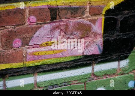 Graffiti – Wolverhampton 2026 – Nahaufnahme – verblasste Details zeigen Schichten von früheren Werken auf demselben Wandabschnitt. Stockfoto