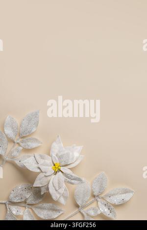 beiger Weihnachts-Hintergrund mit weißen Weihnachtssternen und glitzerndem Laub für Weihnachtsgrußkarte, Banner und Winterdesign Stockfoto