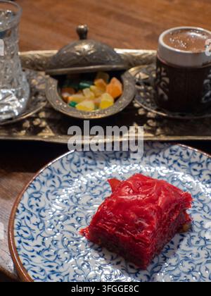 Baklava, kandierte Früchte, ein Glas Wasser und eine Tasse türkischer Kaffee auf einem getriebenen Metalltablett. Stockfoto
