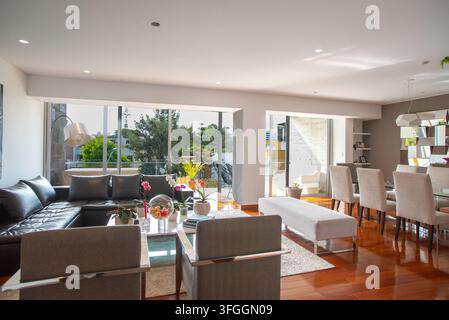 Moderne Wohn- und Essbereich: Ein geräumiger, offener Wohn- und Essbereich mit einem großen Ecksofa und einem eleganten Essset Stockfoto
