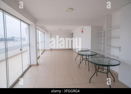 Moderne Wohnungsinnenausstattung: Eine leere, zeitgenössische Wohnung mit bodentiefen Fenstern, die Panoramablicke bieten, mit einem geräumigen Wohnbereich Stockfoto