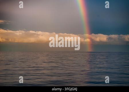 Regenbogen über dem Nordatlantik mit dramatischen Sturmwolken und ruhiger See Stockfoto