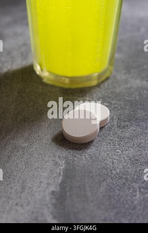 Brausetablette auf Tisch mit Glas. Nahrungsergänzungsmittel mit Magnesium und Vitaminen Stockfoto