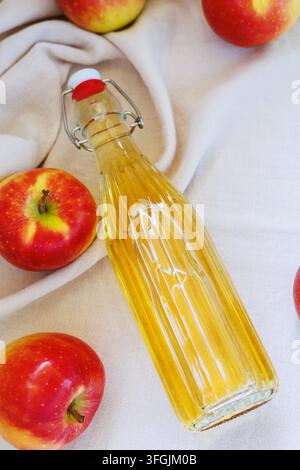 Oberansicht einer hausgemachten Apfelsaftflasche mit roten Äpfeln Stockfoto