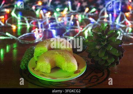Bunte dekorative Weihnachtslichter, Donuts und herbstliche Tannenzapfen. Stockfoto