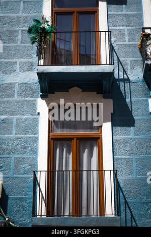 Farbenfrohe blaue Fassade eines traditionellen Wohngebäudes in Murcia, Spanien, mit eleganten schmiedeeisernen Balkonen, Holzfenstern und dekorativem a Stockfoto