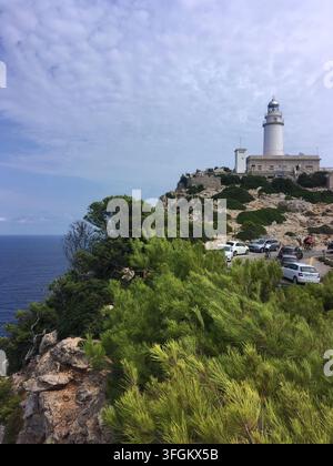 Felsige Küste bei Cap de Formentor, Mallorca, Spanien, mit einem weißen Leuchtturm auf einer Klippe. Mittelmeervegetation mit Kiefern (Pinus Stockfoto