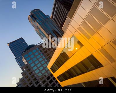 Nahaufnahme von Gebäuseglasfenstern und Reflexion der untergehenden Sonne. Stockfoto