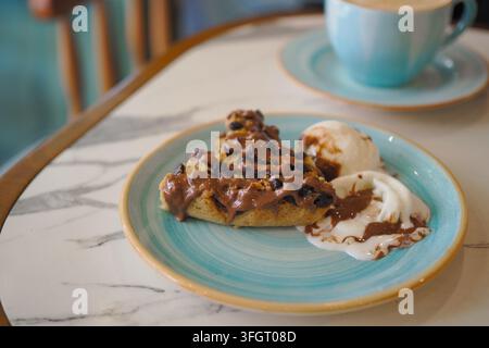 Genießen Sie ein köstliches Dessert, begleitet von cremiger Eiscreme in einer gemütlichen Café-Atmosphäre Stockfoto