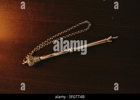 Silberner traditioneller Toravorleser mit Kette, der auf einem Tisch ruht Stockfoto