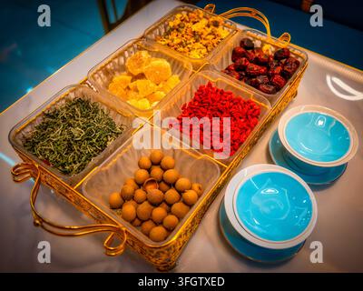 Vollständiges Set an Zutaten für Sanpantai-Tee aus einem Halal-Restaurant in Zhangye. Grüner Tee, Wolfsbärchen, rote Zizifeere, Longan, Rockzucker und Chrysantheme verpackt in Gold Stockfoto