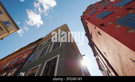 Mehrfarbige alte Häuser in Stockholm. Schöne europäische Architektur, die Sonne scheint hinter dem Dach des Hauses Stockfoto