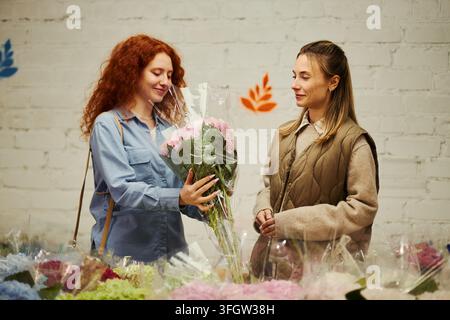 Frau kauft frischen Blumenstrauß beim Floristen im Laden Stockfoto