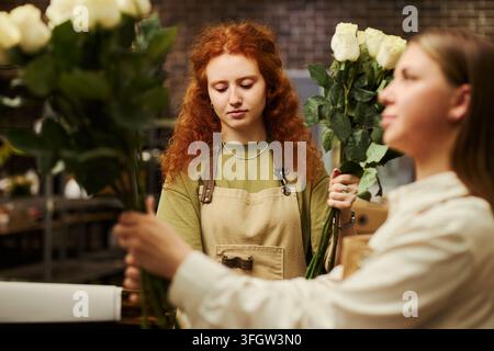 Floristin arbeitet mit frischen Rosen im Blumenladen Stockfoto