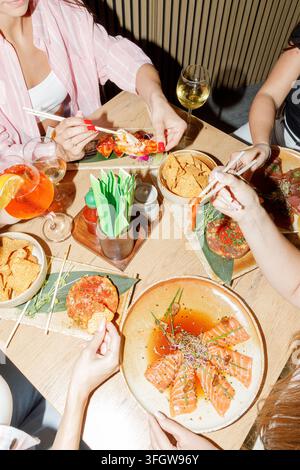 Gruppe von Freunden genießt zusammen eine köstliche asiatische Fusion-Mahlzeit Stockfoto