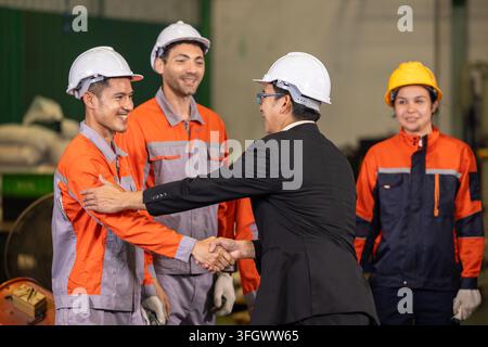 Hauptingenieur gratuliert jungen Ingenieur mit Händedruck. Anerkennung für herausragende Leistung während der Teambesprechung im Werk. Positive Führung und Stockfoto