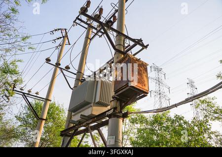 Aufwärtsaufnahme eines alten Beton-Verteilermastes mit einem Transformator Stockfoto