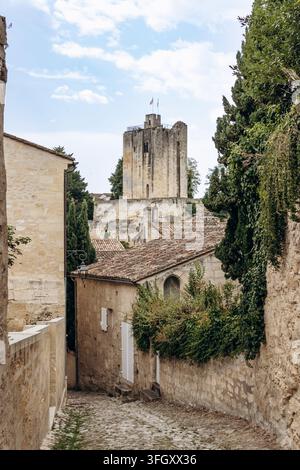 Schmale Kopfsteinpflastergasse, gesäumt von alten Steinhäusern, die auf einen historischen Turm in Saint Emilion führen, einem berühmten Weinort in der Gironde im Südwesten Frankreichs Stockfoto