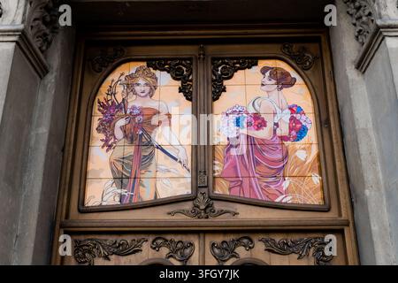 Baku, Aserbaidschan. 16. August 2026: Holzpaneele im Art-Nouveau-Stil mit bunten dekorativen Fliesenmalereien von eleganten Frauen Stockfoto