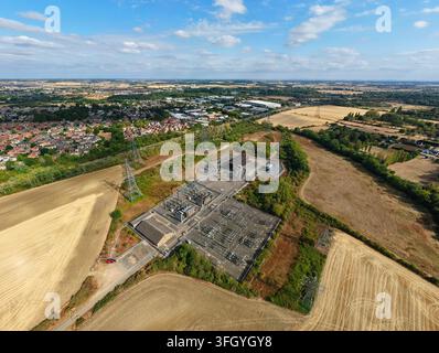 Luftbild der Eaton-Socon-Unterstation mit umliegenden Agrarfeldern, Stromleitungen und der Stadt St. Neots im Hintergrund, St. Neots, Engla Stockfoto