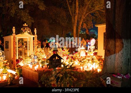 Traditionelle Feier zum Tag der Toten auf einem Friedhof in Michoacán, Mexiko, wo sich Familien nachts versammeln, um verstorbene Angehörige zu ehren. Gräber und Ma Stockfoto