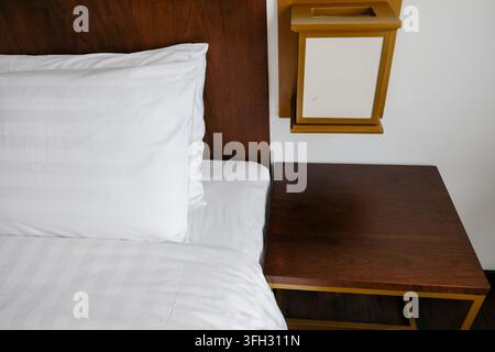 Moderner hölzerner Nachttisch und Nachttisch in einem Hotelzimmer-Interieur Stockfoto