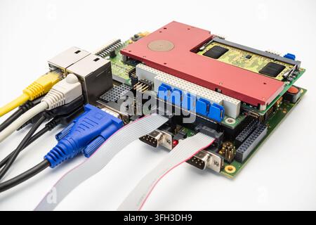 Eine Leiterplatte zeigt verschiedene Anschlüsse und Kabel, die in einem Arbeitsbereich an sie angeschlossen sind. Das Bild zeigt eine Nahaufnahme des technischen Aufbaus. Stockfoto
