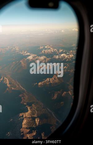 Luftbild von Bergen aus dem Flugzeugfenster, atmosphärlicher Reisehintergrund Stockfoto