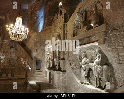 WIELICZKA, POLEN - 16. SEPTEMBER 2022: Ein salzgeschnitztes Relief, das den Flucht nach Ägypten darstellt, ist neben einem Kronleuchter beleuchtet Stockfoto