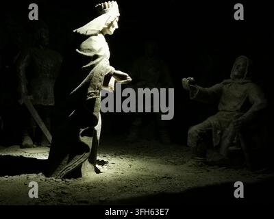 WIELICZKA, POLEN – 16. SEPTEMBER 2022: Eine ins Rampenlicht gerückte, aus Salz gehauene königliche Figur hebt sich von der Dunkelheit ab Stockfoto